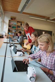 Robotikprojekt in der Klasse 6c Lungern: Jeremias Bucher (stehend im roten Shirt) gibt den Schülern wertvolle Tipps. (Bild: Marion Wannemacher (Lungern, 27. September 2017))