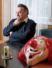 Der Sarner Pfarrer Bernhard Willi im Pfarrhaus mit einer Maske, die er für Bekannte aufbewahrt. An der Fasnacht trägt er selber keine Masken – «man kennt mich». (Bild: Corinne Glanzmann (Sarnen, 7. Februar 2017))