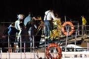 Einsatzkräfte der Feuerwehr bei der Evakuierung von Personen mit Rettungsdecken auf ein anderes Schiff. Ein Hotelschiff mit 129 Personen war am späten Dienstagabend auf dem Rhein mit einem Brückenpfeiler kollidiert. (Bild: Marcel Kusch/DPA)