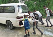 Bevor die Kinder einsteigen können, müssen sie ihren altersschwachen Schulbus erst mal anschieben. (Bild: PD)