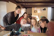 Magdalena Bucher (links) und Elionora Amstutz (vorne links) betrachten zusammen mit Kindern auf ihrer Entdeckungsreise durch das Winkelriedhaus ein Praxinoskop. (Bild: Marion Wannemacher (Stans, 15. März 2017))