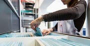 Eine medizinische Praxisassistentin ordnet Krankenakten ein. Ärzte befürchten, dass der neue Tarif zu mehr Bürokratie und damit zu mehr Kosten führen wird. (Bild: Christian Beutler/Keystone)