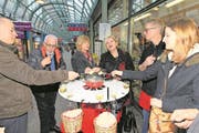 Teilnehmer der Führung geniessen in der Neustadt-Passage ein Zuger Fondue. (Bild: Charly Keiser (8. März 2018))