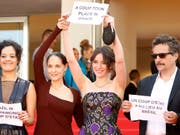 "Stoppt den Putsch": Protest auf dem roten Teppich. Das brasilianisches Filmteam um den Regisseur Kleber Mendonça Filho verurteilt die Suspendierung von Brasiliens Präsidentin Rousseff. (Bild: KEYSTONE/EPA/GUILLAUME HORCAJUELO)