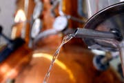 Frisch gebrannter Williams-Schnaps läuft aus einem Rohr der Destillerie in einen Kessel. (Symbolbild Keystone / Sigi Tischler)