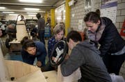 Drei Schüler bauen eine Seifenkiste zusammen, unter dem wachsamen Blick der Aufsichtsperson. (Bild: Corinne Glanzmann (Sarnen, 28. März 2018))