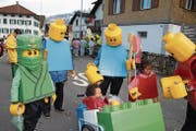 Drei Generationen Omlin als Lego-Männchen. Diyan als Ninjakrieger (ganz links im Bild), Niilo im Wagen und Tia ohne Maske. (Bild: Marion Wannemacher (Sachseln, 23. Februar 2017))