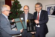 Die Verantwortlichen der Tell-Museumsgesellschaft, Paul Arnold (links) und Erich Herger (rechts), verabschieden Konservator Hans Jörg Kuhn. (Bild Paul Gwerder)