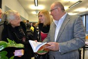 Alexandra Hürlimann (19) betrachtet mit Franz Scheuber (73) und Silvia Gessner (72) ihre Maturaarbeit zum Thema «Wertewandel in der Erziehung». (Bild: Romano Cuonz / Neue NZ)