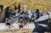 Experten untersuchen das Wrack-Teil des abgestürzten Helikopters. (Bild: KEYSTONE/Ti-Press/Samuel Golay)