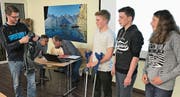 Reto Wyss überreicht den Athleten Cornel Bretscher, Jonah Müller und Hannah Müller ein Trikot. (Bild: PD)