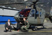 Systemplaner und Projektleiter des DVE-Projektes Samuel Allemann (links) und der Pilot Michael Hügli knien vor dem von der Schweizer Luftwaffe für das Projekt «Fliegen bei schlechten Sichtverhältnissen» ausgerüsteten EC 635.