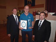 Bruno Kaiser nimmt für den Skiclub Hergiswil den Anerkennungspreis von Hergiswil entgegen. Links Gemeindepräsident Remo Zberg, rechts Gemeinderat Alfonso Ventrone. (Bild: Kurt Liembd (Hergiswil, 2. Januar 2018))