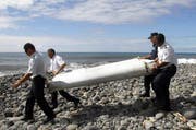 Offiziere tragen im Juli 2015 ein Wrackteil der verschwundenen Maschine der Malaysia Airlines. (Bild: Keystone / Raymond Wae Tion)