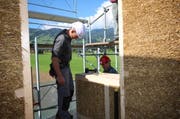 Wie bei Lego: Arbeiter setzen in Giswil die Strohmodule zu einem Haus zusammen. (Bild: Marion Wannemacher / Neue OZ)