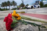 Jemand hat Nelken und eine Sonnenblume auf den Bordstein gelegt. (Bild: Keystone/EPA/Cristobal Herrera)