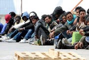 Migranten warten im April 2011 auf ein Schiff, welches Sie von Lampedusa aufs Festland bringen soll. (Bild: Keystone / Archiv)