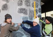 Marcel Zgraggen, Sandra Indergand und Erich Furrer (von links) zeichnen auf der Vorderseite des Wagens ein Fenster für den Fahrer ein. (Bild: Markus Zwyssig (Erstfeld, 3. Februar 2018))