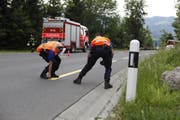 Polizisten vermessen die Unfallstelle. (Bild: Geri Holdener)