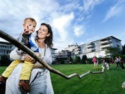 Franziska Zweifel schaut sich mit Sohn Lionel die Skulptur «Atemzug» von Kari Koller im Martinspark an. (Bild: Stefan Kaiser)