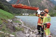 Franz Exer von der Feuerwehr Altdorf birgt zusammen mit einem Rettungssanitäter des Kantonsspitals Uri eine Puppe aus der Reuss. (Bild: Remo Infanger (Erstfeld, 26. August 2017))