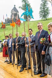 Oben: Beat Villiger, Andreas Barraud, Ueli Maurer, André Rüegsegger und Heinz Tännler mit ihren Hellebarden (von links). Unten: Werbung für das Freilichtspektakel. (Bilder Christian Hildebrand)