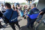 Polizisten bewachen Personen beim Eingang in Genf. (Bild: Keystone / Martial Trezzini)