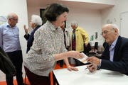Nach seinem Vortrag in der Kantonsschule Sarnen signiert Angelo Garovi sein neues Büchlein «Obwaldner Flurnamen». (Bild Robert Hess)