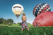 Faszination pur: Zuschauer bestaunen vor dem Dorfeingang, wie die Ballone in die Höhe steigen. (Bild: Dominik Wunderli (Geiss, 26. August 2017))