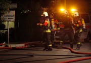 Feuerwehr-Angehörige rüsten sich für den Löscheinsatz. (Bild: Geri Holdener, Bote der Urschweiz)
