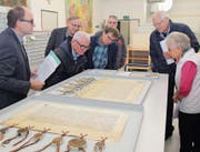Staatsarchivar Hans Jörg Kuhn (links) bei einer Führung zusammen mit Besuchern, die über die sehr gut erhaltenen historischen Dokumente staunen. (Bild: Paul Gwerder (Altdorf, 18. November 2017))