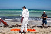 28. August 2015: Im libyschen Zuwara ziehen Rettungskräfte Leichen aus dem Meer und verpacken sie in Leichensäcke. Die Flüchtlinge starben, nachdem zwei Schlepper-Boote gekentert waren. (Bild: AP/Giannis Papanikos)