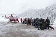 Touristen warten auf dem Heliport der Air Zermatt auf die Ausreise. (Bild: Dominic Steinmann / Keystone (Zermatt, 9. Januar 2018))