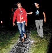 Armin Kiser (rechts) führt Lambert Liesenberg über den glühend heissen Feuerteppich. (Bild: Romano Cuonz)