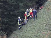 Im steilen Hang kümmert man sich um den Verunglückten. (Bild: Geri Holdener, Bote der Urschweiz)