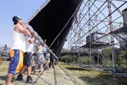 Die Tribüne aufzubauen, kostete die Arbeiter gestern einiges an Kraft und Schweiss (oben). Die Leinwand zu heben, war leichter (unten). (Bilder Werner Schelbert)