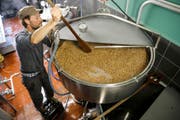 Der Bierbrauer Christophe Haeni ruehrt mit einer Holzkelle in der Maischepfanne (Bild: PETER KLAUNZER (KEYSTONE))