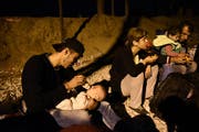 1. September 2015: Abed Hadi (19) füttert seinen Neffen nahe der Grenze zwischen Griechenland und Mazedonien. (Bild: AP/Giannis Papanikos)