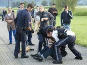 Polizisten nehmen nach einer Messerattacke in einem Regionalzug in Vorarlberg den Verdächtigen fest. Der 60-jährige Deutsche stach mit einem Messer auf zwei Fahrgäste ein. (Bild: KEYSTONE/APA/DIETMAR MATHIS FOTOGRAFIE)