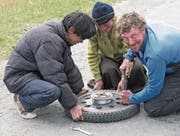 Monika Estermann und Robert Spengeler auf Reisen: in Bolivien (links), Indien (oben rechts) und beim Reifenwechsel (unten rechts). (Bilder: PD)