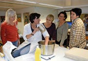 Die in Tschechien lebende Obwaldner Künstlerin Doris Windlin (mit weisser Schürze) leitet einen Malkurs in Obwalden. (Bild Romano Cuonz)