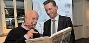 Autor Martin Weiss (links) und der Urner Landammann Beat Jörg schmökern im neuen Comic-Band «Die Munggenstalder in der Teufelsschlucht». (Bild: Urs Hanhart (Altdorf, 27. April 2017))