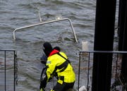 Spezialisten der Seepolizei und der Feuerwehr bereiten das Boot für die Bergung vor. (Bild: Geri Holdener, Bote der Urschweiz)