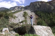 Riesige Felsbrocken liegen nach dem Felssturz hinter dem Dorf Felsberg. (Bild: Arno Balzarini / Keystone (Felsberg, 7. Juli 2001))