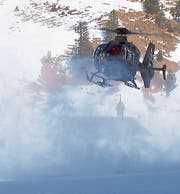 Die Besatzung des EC-635-Helikopters, der auf der Älggialp zum Landen inmitten des aufgewirbelten Schnees ansetzt. (Bild: Schweizer Armee / VBS)