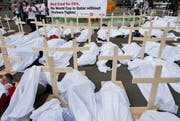 Gewerkschaftsaktivisten unter Leichentüchern: Mit ihrem Protest vor dem Hallenstadion erinnern sie an die vielen Toten auf den Baustellen der WM in Katar. (Bild: Keystone / Ennio Leanza)