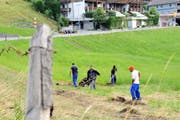 Asylsuchende säubern das Wiesland in Stalden von den letzten Spuren des Unwetters Ende Juni. (Bild Adrian Venetz)