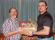 Präsident Urs Gysin (rechts) überreicht Ruedi Moser ein Präsent für 60 Jahre Vereinstreue. (Bild: PD)