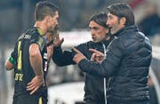 Murat Yakin (rechts), Cheftrainer der Grasshoppers, bespricht sich mit Verteidiger Milan Vilotic, während sich sein Assistent Hakan Yakin (Zweiter von rechts) um die Offensivspieler kümmert. (Bild: Peter Schneider/Keystone (Thun, 21. September 2017))