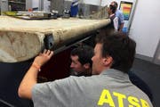 Australische Experten untersuchen ein Trümmerstück. Auf der Pemba Insel wurde ein Trümmerstück eines Flugzeuges gefunden, dass die Behörden dem verschollenen MS370-Flugzeug zuordnen. (Bild: EPA/ATSB AUSTRALIA AND NEW ZEALAND)